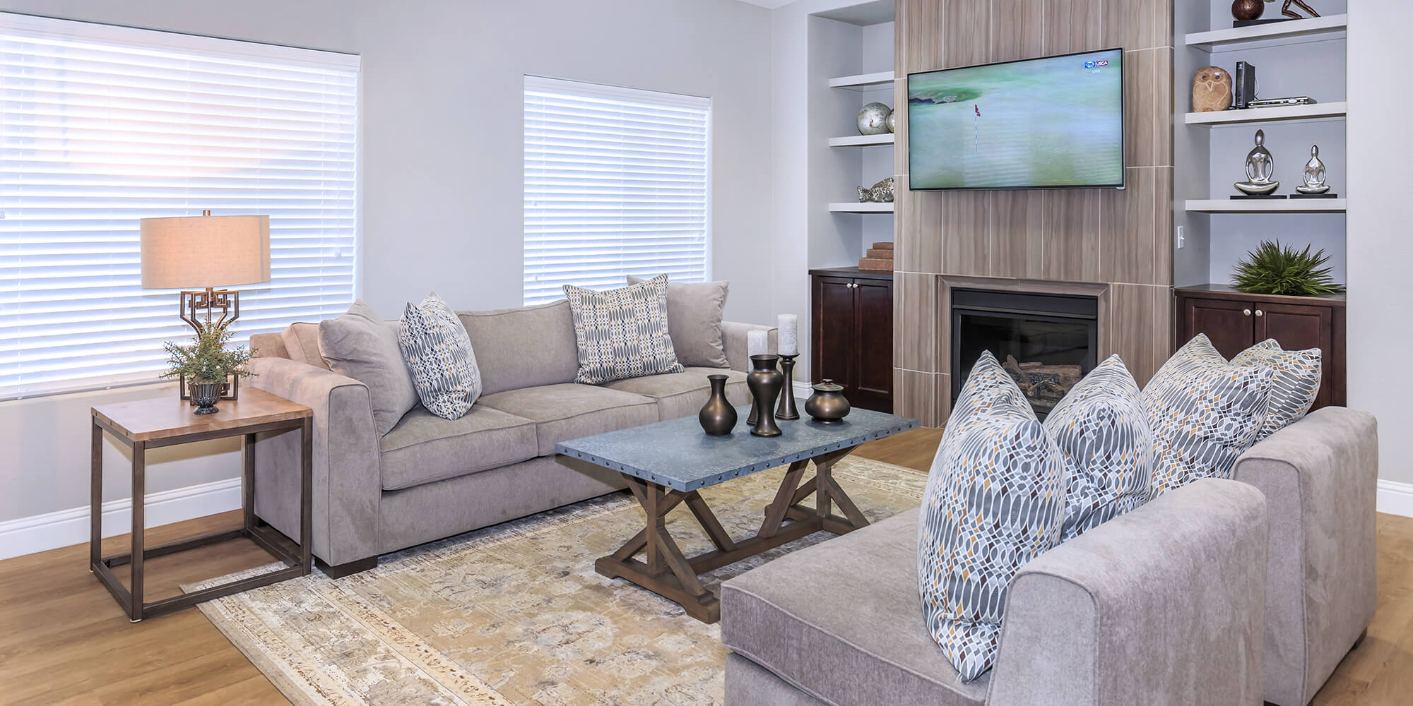 Living room seating area with a television over the fireplace